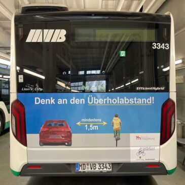 Grafiken auf Bussen werben für mehr Verkehrssicherheit beim Überholen von Radfahrenden